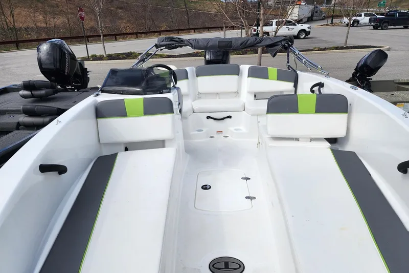 Slide: The Image of 2023 Tahoe T18 boat interior with gray and green seating, parked outdoors. - 3