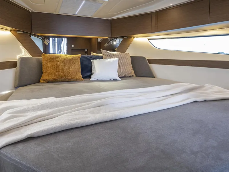 Slide: The Image of Manufacturer Provided Image: 2025 Beneteau Antares 11 cabin interior with cozy bed and decorative pillows. - 16