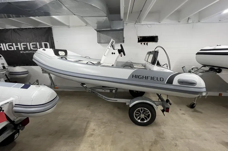 The Image of 2026 Highfield Sport 360 boat on trailer in showroom setting. - 1