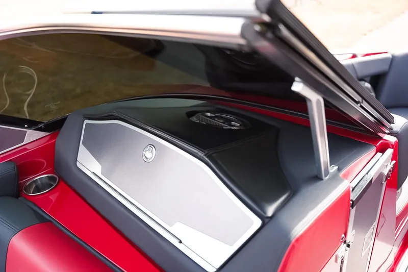 Slide: The Image of 2019 MasterCraft X24 boat interior with sleek red and black design, featuring storage compartment. - 22