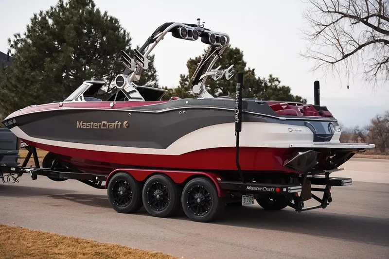 Slide: The Image of 2019 MasterCraft X24 boat on trailer, parked outdoors, showcasing sleek design and vibrant colors. - 4