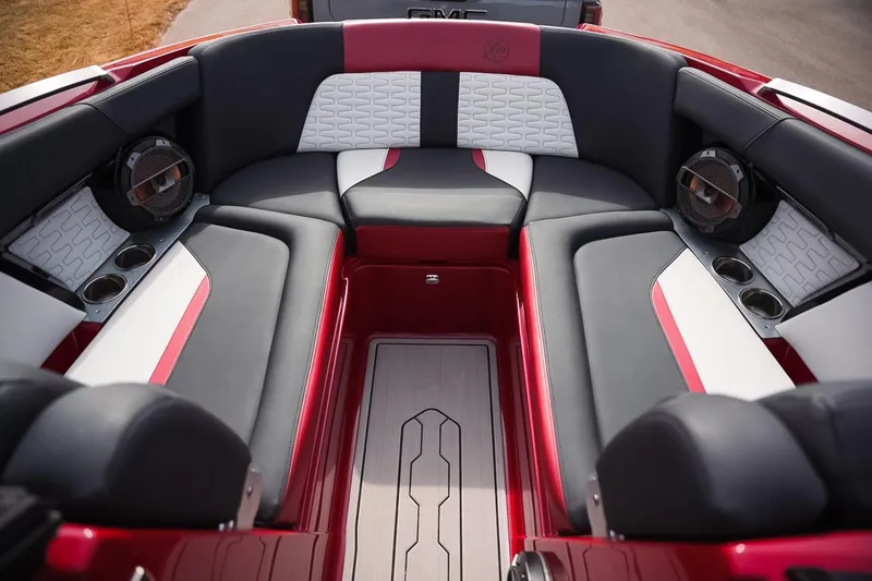 Slide: The Image of 2019 MasterCraft X24 boat interior with red, black, and white seating and built-in speakers. - 8