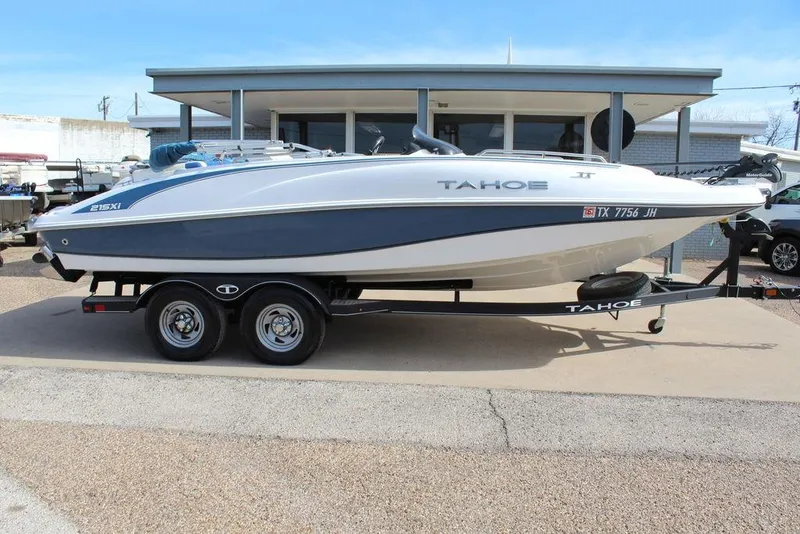 The Image of 2020 Tahoe 215 Xi boat on trailer, parked outdoors, side view. - 1