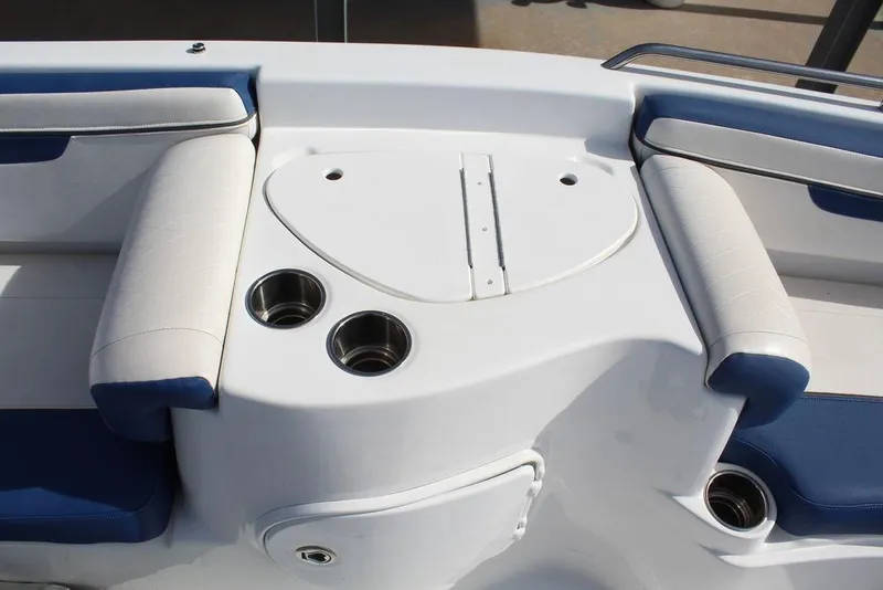 Slide: The Image of 2020 Tahoe 215 Xi boat interior with white and blue seating, cup holders, and sleek design. - 19