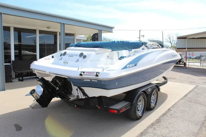 Slide: The Image of 2020 Tahoe 215 Xi boat on trailer, parked outdoors near a building. - 5