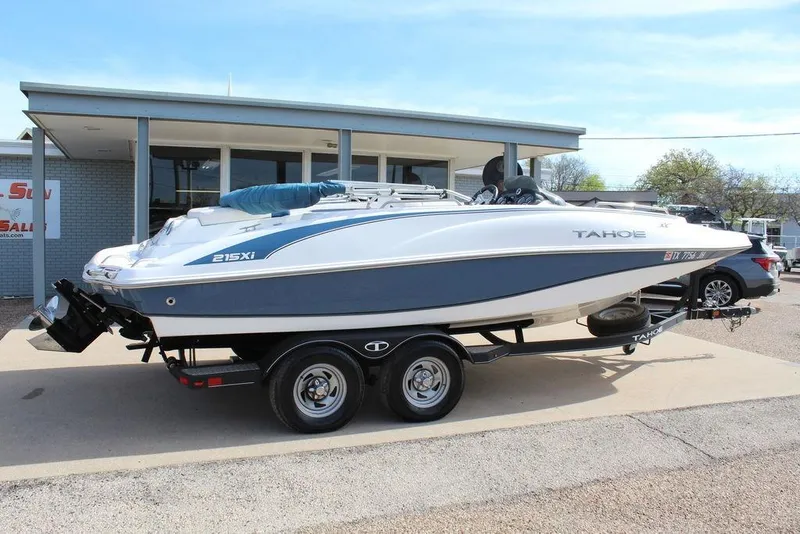 Slide: The Image of 2020 Tahoe 215 Xi boat on trailer, parked outside a building. - 6