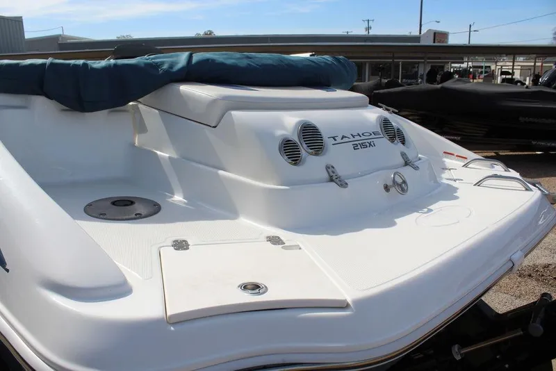 Slide: The Image of 2020 Tahoe 215 Xi boat rear view with sleek white design and covered seating area. - 7