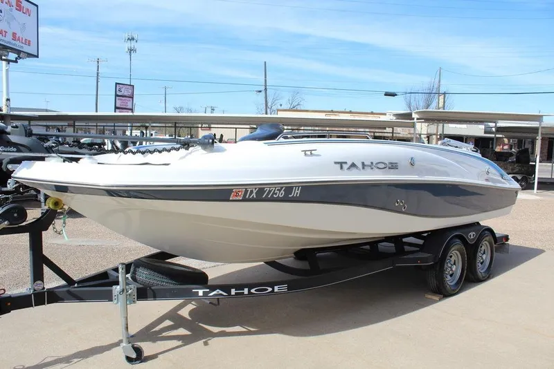 Slide: The Image of 2020 Tahoe 215 Xi boat on trailer, displayed outdoors in a dealership setting. - 9