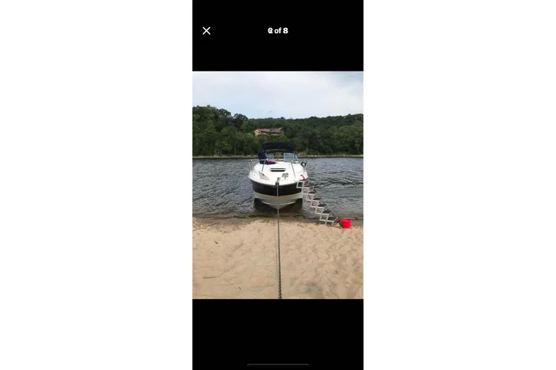 Slide: The Image of A 2005 Regal 2750 boat docked on a sandy beach with a ladder. - 11