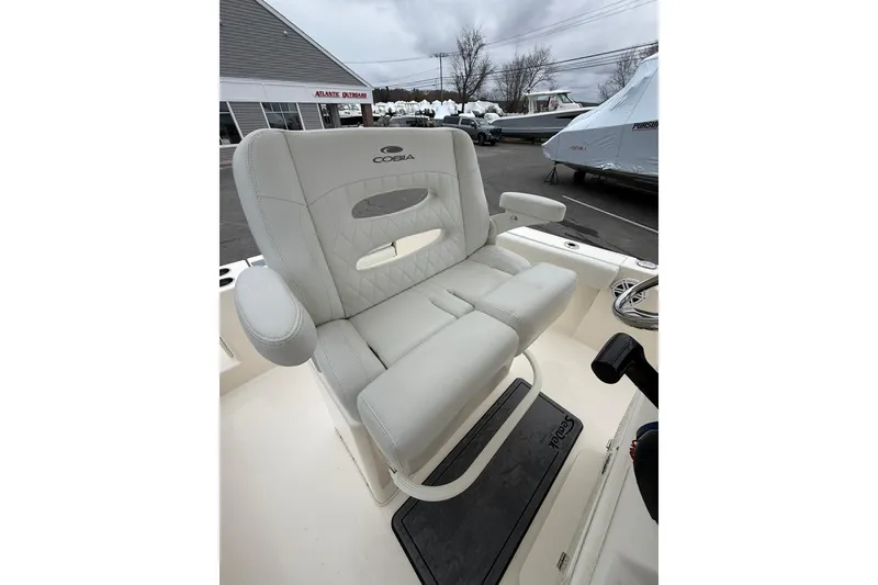 Slide: The Image of 2022 Cobia 220 Center Console boat seat with armrests, displayed outdoors. - 11