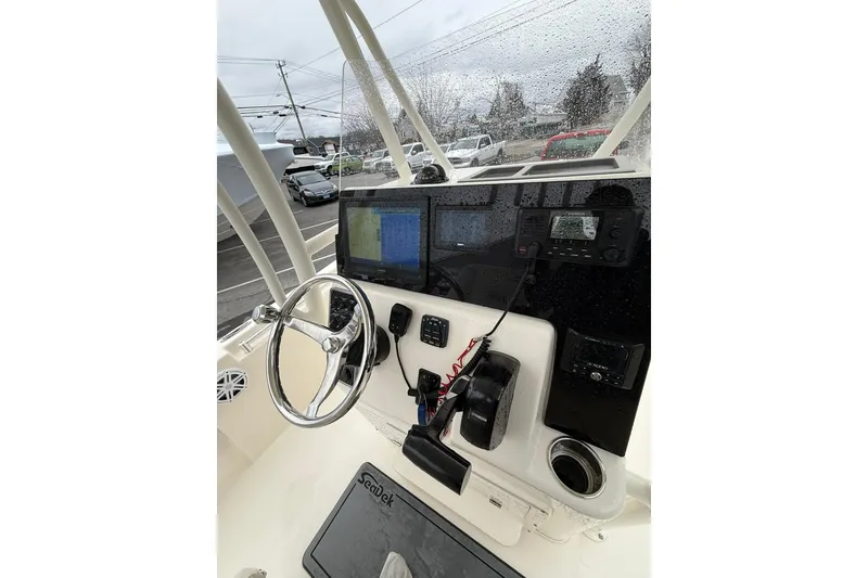 Slide: The Image of 2022 Cobia 220 Center Console boat dashboard with steering wheel and navigation equipment. - 12