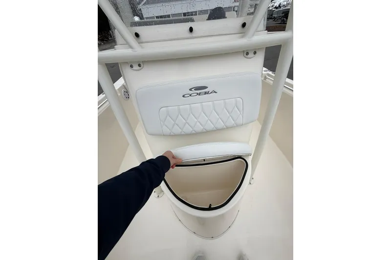 Slide: The Image of 2022 Cobia 220 Center Console boat with storage compartment open. - 17