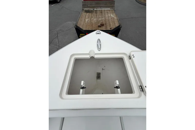 Slide: The Image of 2022 Cobia 220 Center Console boat bow with open hatch, parked on trailer. - 18