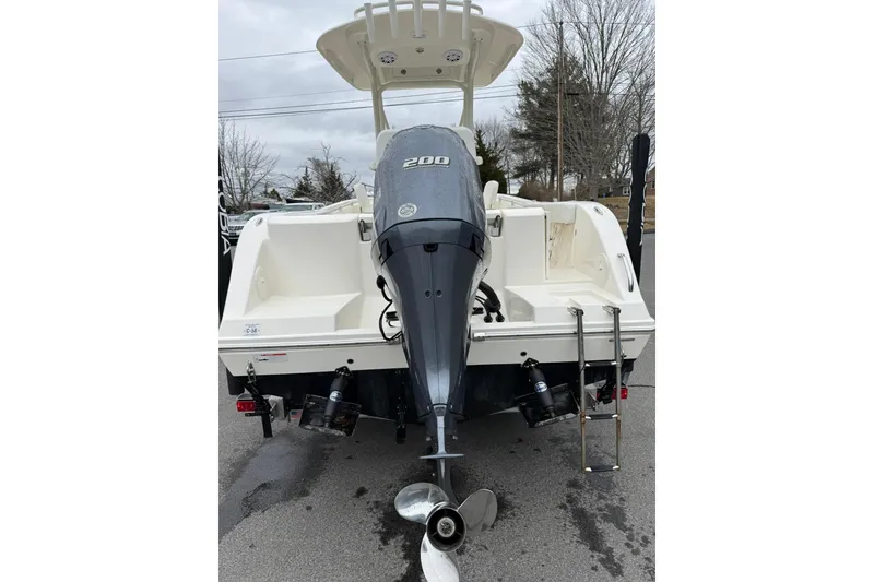 Slide: The Image of 2022 Cobia 220 Center Console boat with powerful outboard motor and ladder. - 23