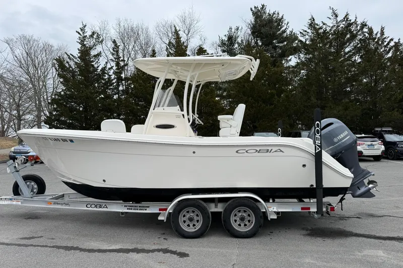 Slide: The Image of 2022 Cobia 220 Center Console boat on trailer, parked outdoors. - 25