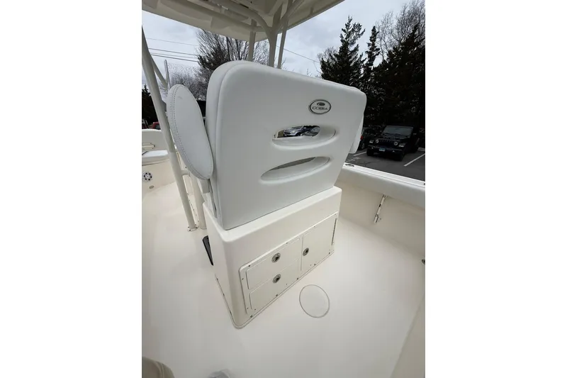 Slide: The Image of 2022 Cobia 220 Center Console boat interior with white seating and storage compartments. - 7