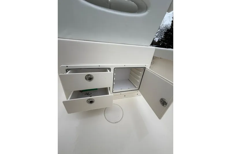 Slide: The Image of 2022 Cobia 220 Center Console storage compartments with open drawers and cabinet. - 9