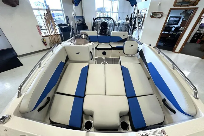 Slide: The Image of 2026 Starcraft SV 16 OB boat interior with blue and white seating in showroom. - 3