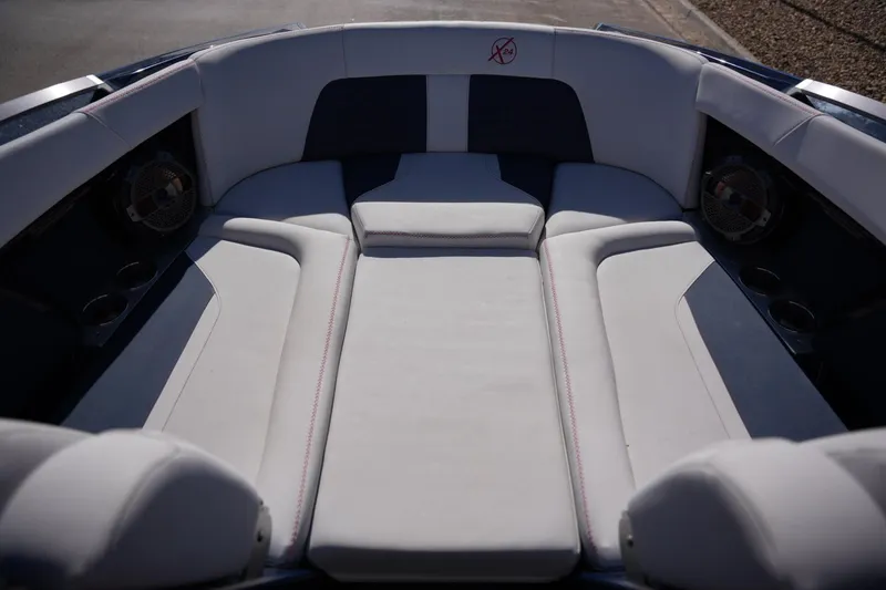 Slide: The Image of 2019 MasterCraft X24 boat interior with white cushioned seating and built-in speakers. - 10