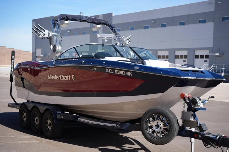 Slide: The Image of 2019 MasterCraft X24 boat on trailer, parked outside industrial building. - 6