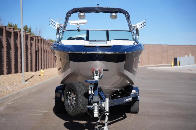 Slide: The Image of 2019 MasterCraft X24 boat on trailer, parked outdoors on a sunny day. - 7