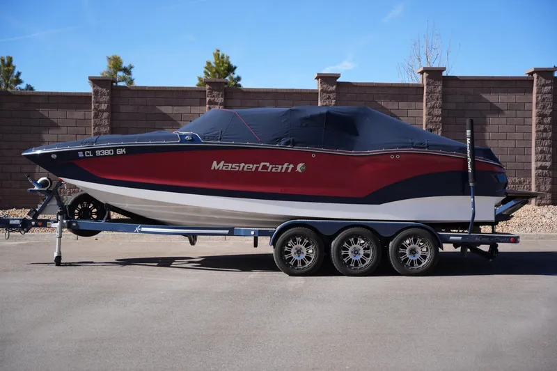 Slide: The Image of 2019 MasterCraft X24 boat on trailer, covered, parked outdoors. - 9