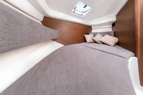 Slide: The Image of 2024 Beneteau Antares 8 V2 cabin interior with cozy bedding and cushions. - 12