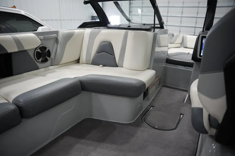 Slide: The Image of 2020 Malibu Wakesetter 21 VLX interior with gray and white seating, speaker, and carpeted floor. - 12