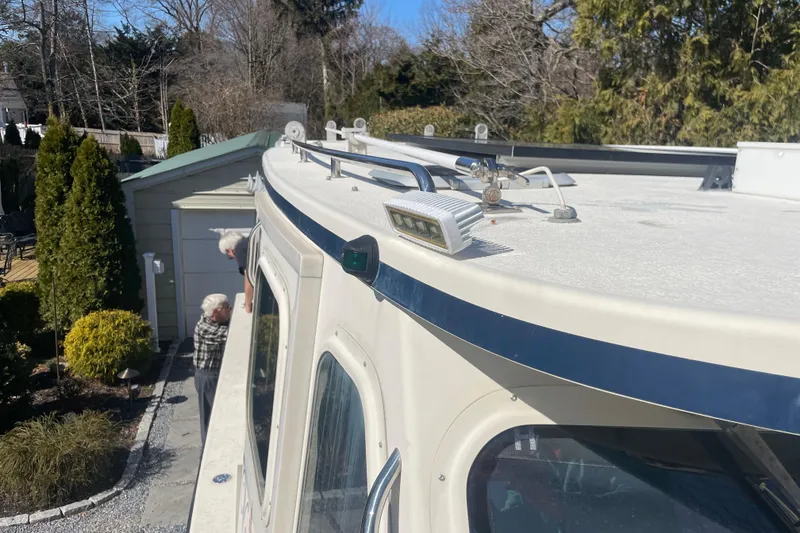 Slide: The Image of 2007 Rosborough RF-246 Sedan Cruiser docked near a garden with trees and shrubs. - 21