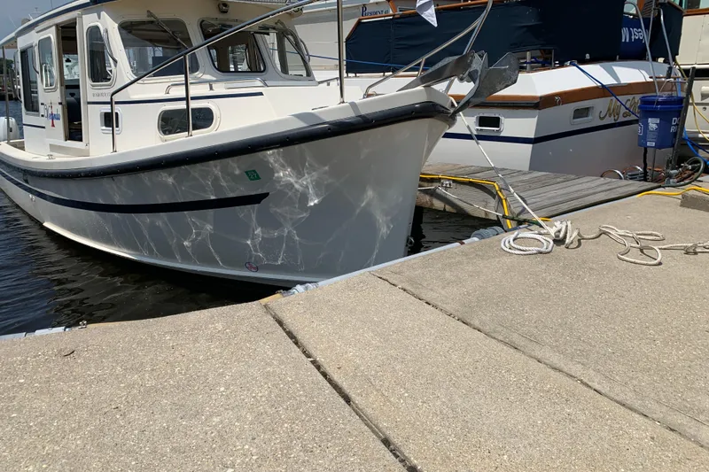 Slide: The Image of 2007 Rosborough RF-246 Sedan Cruiser docked at marina, reflecting sunlight on water. - 7