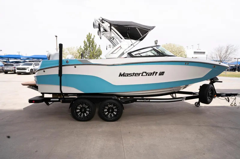 Slide: The Image of 2022 MasterCraft XT22 boat on trailer, featuring sleek design and vibrant blue accents. - 3