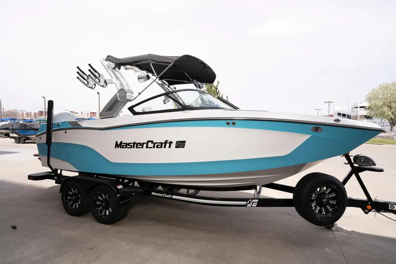 Slide: The Image of 2022 MasterCraft XT22 boat on trailer, featuring sleek design and vibrant blue accents. - 4