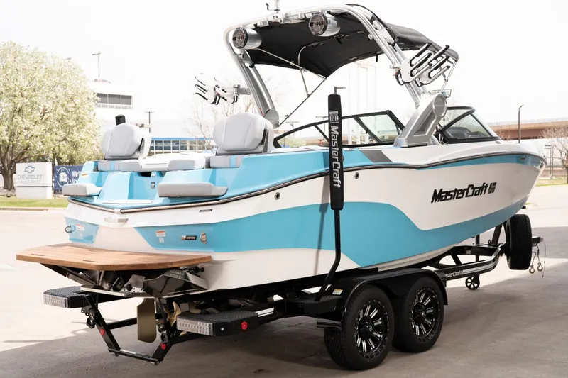 Slide: The Image of 2022 MasterCraft XT22 boat on trailer, featuring sleek design and vibrant blue accents. - 6