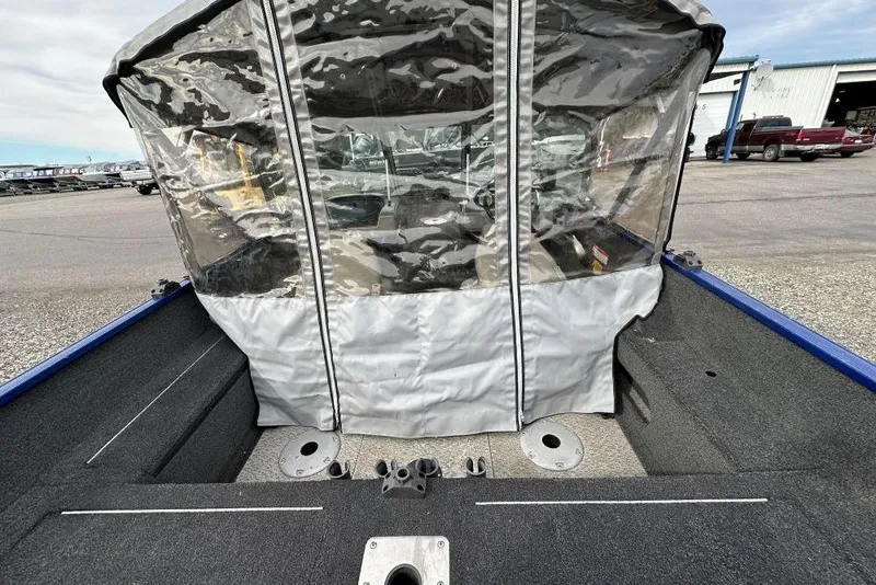 Slide: The Image of 2014 Lowe Fishing Machine 165WT Pro with protective canopy in a parking lot. - 4