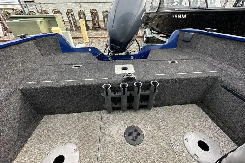 Slide: The Image of 2014 Lowe Fishing Machine 165WT Pro interior with rod holders and motor view. - 7