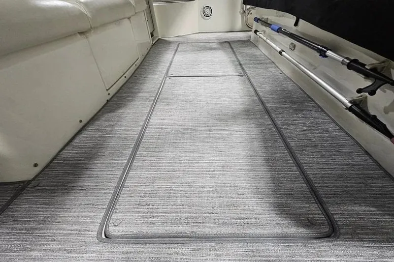 Slide: The Image of Interior view of a 1995 Tiara Yachts 4000 Express, featuring a carpeted floor and fishing rods. - 18
