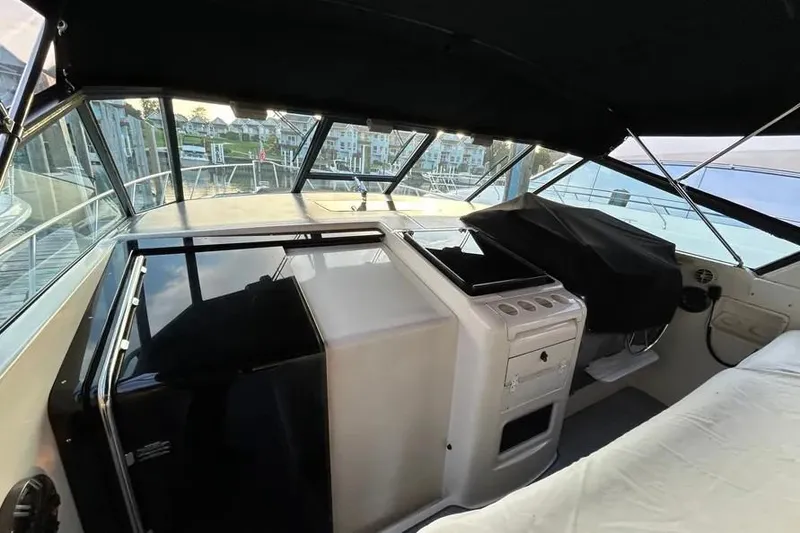 Slide: The Image of 1995 Tiara Yachts 4000 Express interior with helm and marina view. - 27