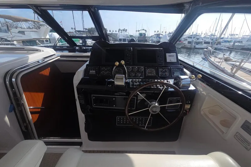 Slide: The Image of Helm of 2001 Tiara Yachts 5200 Express with steering wheel and navigation controls. - 12
