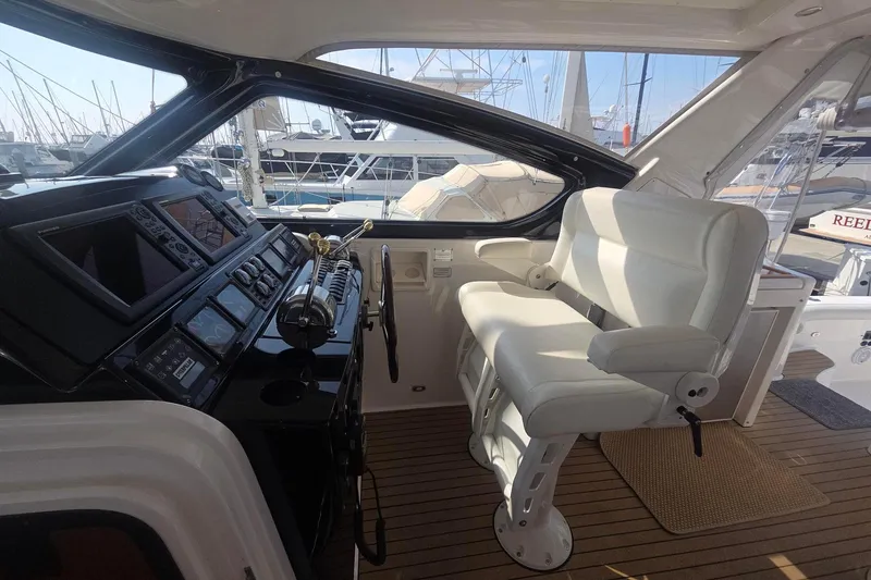 Slide: The Image of Cockpit of 2001 Tiara Yachts 5200 Express with white captain's chair and control panel. - 13
