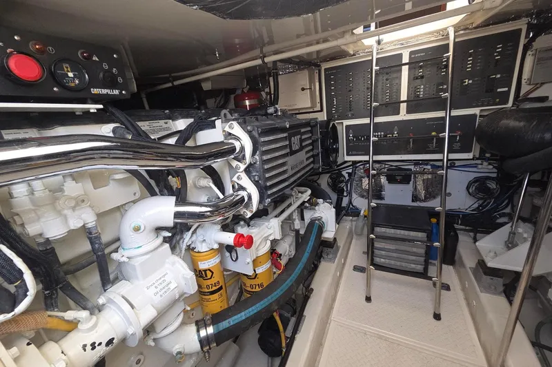 Slide: The Image of Engine room of a 2001 Tiara Yachts 5200 Express, featuring Caterpillar machinery and control panels. - 14