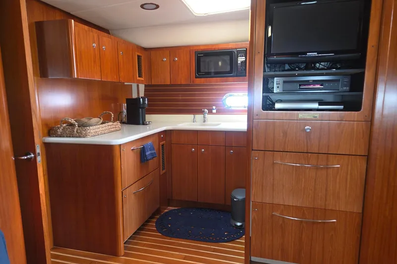 Slide: The Image of Luxurious 2001 Tiara Yachts 5200 Express interior kitchen with wood cabinetry and modern appliances. - 20