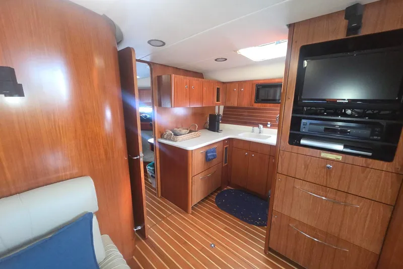 Slide: The Image of Interior of 2001 Tiara Yachts 5200 Express, featuring wood cabinetry and modern amenities. - 22