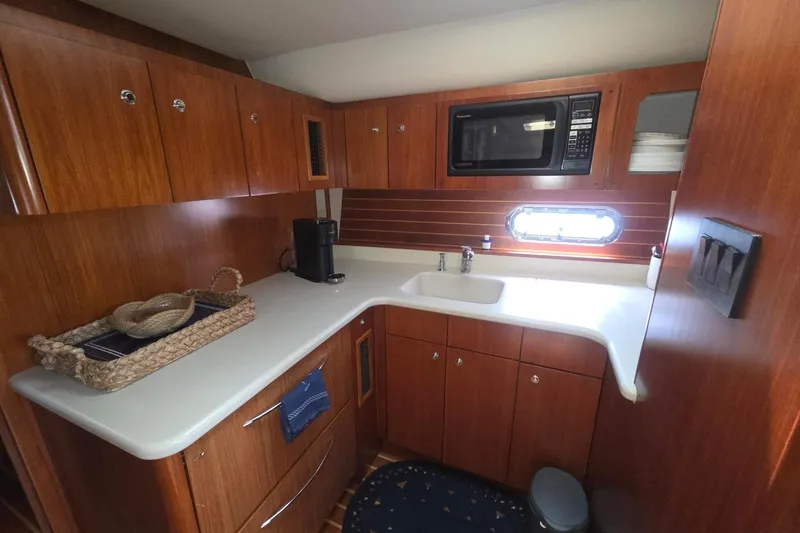 Slide: The Image of 2001 Tiara Yachts 5200 Express kitchen with wooden cabinetry and modern appliances. - 24