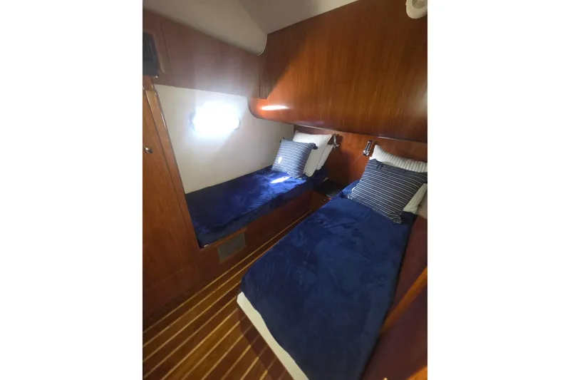 Slide: The Image of Cozy twin cabin with blue bedding in 2001 Tiara Yachts 5200 Express. - 28