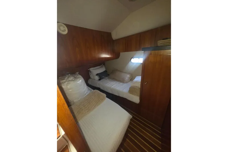 Slide: The Image of Cabin interior of 2001 Tiara Yachts 5200 Express with twin beds and wooden paneling. - 29