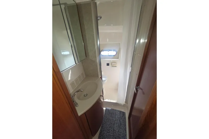 Slide: The Image of Bathroom interior of 2001 Tiara Yachts 5200 Express, featuring sink and mirror. - 31