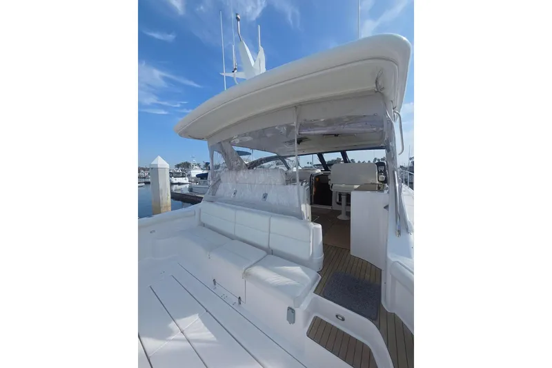Slide: The Image of 2001 Tiara Yachts 5200 Express with spacious deck and seating, docked under clear skies. - 4