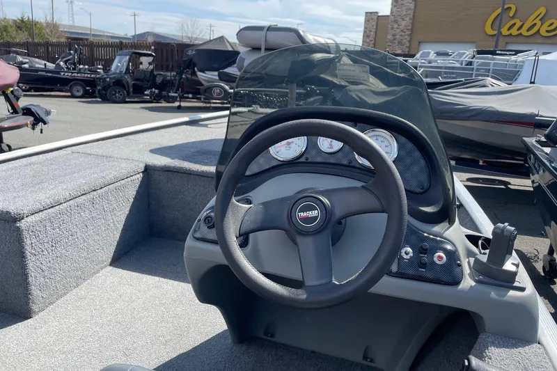 Slide: The Image of 2014 Tracker Pro 170 boat dashboard with steering wheel and gauges in outdoor showroom. - 3
