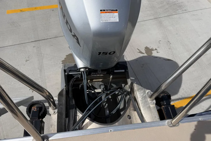 Slide: The Image of 2018 Godfrey Sweetwater 2486 SB with Honda 150 outboard motor on concrete surface. - 14