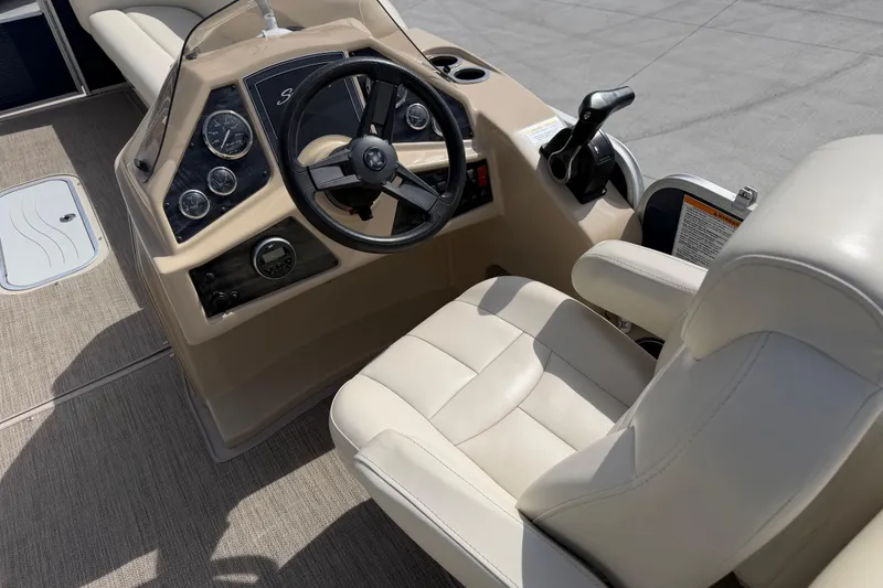 Slide: The Image of 2018 Godfrey Sweetwater 2486 SB boat helm with beige seating and control panel. - 18